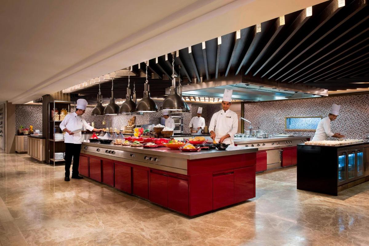 a group of chefs preparing food in a kitchen at JW Marriott Mussoorie Walnut Grove Resort & Spa in Mussoorie