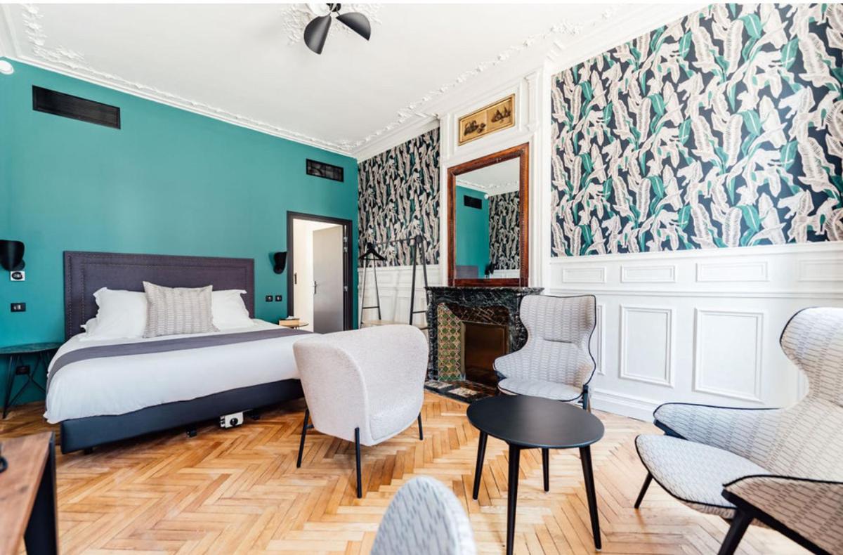 une chambre avec un lit et un mur bleu dans l'établissement La villa 10 HÔTEL SPA, à Étretat