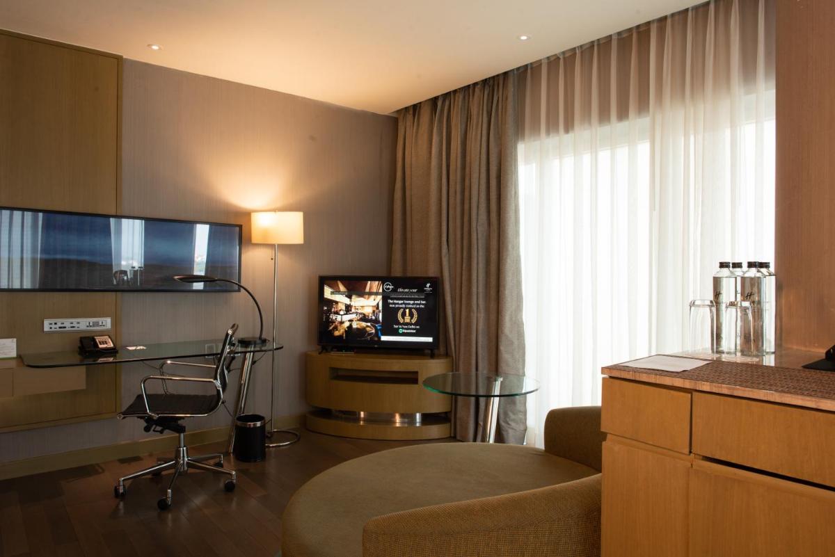 a living room with a television and a couch and a table at Holiday Inn New Delhi Aerocity by IHG in New Delhi
