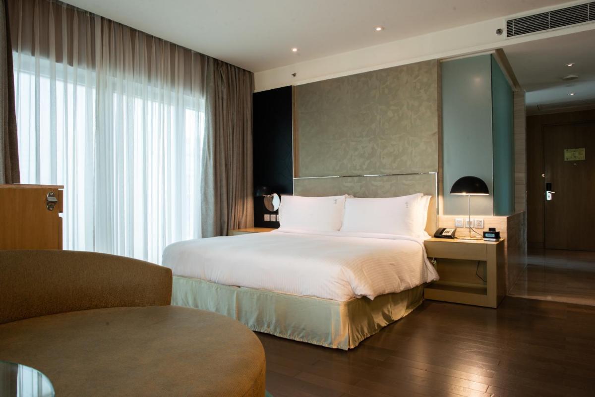 a hotel room with a large bed and a chair at Holiday Inn New Delhi Aerocity by IHG in New Delhi