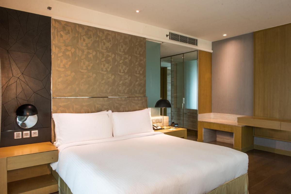 a bedroom with a large white bed and a mirror at Holiday Inn New Delhi Aerocity by IHG in New Delhi