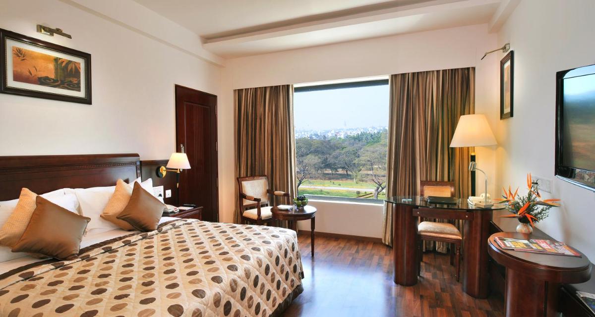 a hotel room with a bed and a desk and a window at Fortune JP Palace, Mysore - Member ITC Hotels' Group in Mysore