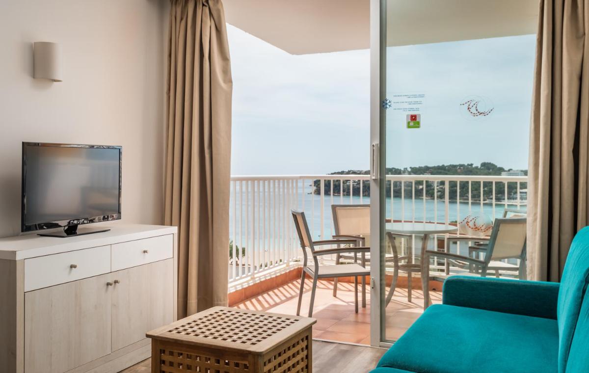 sala de estar con sofá, TV y balcón en Apartamentos Vistasol, en Magaluf