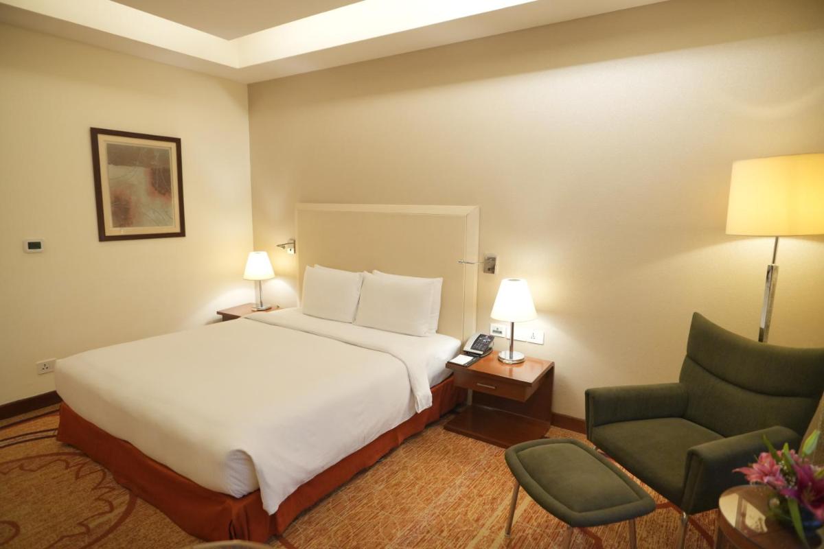a hotel room with a bed and a chair at DoubleTree by Hilton Gurgaon New Delhi NCR in Gurgaon