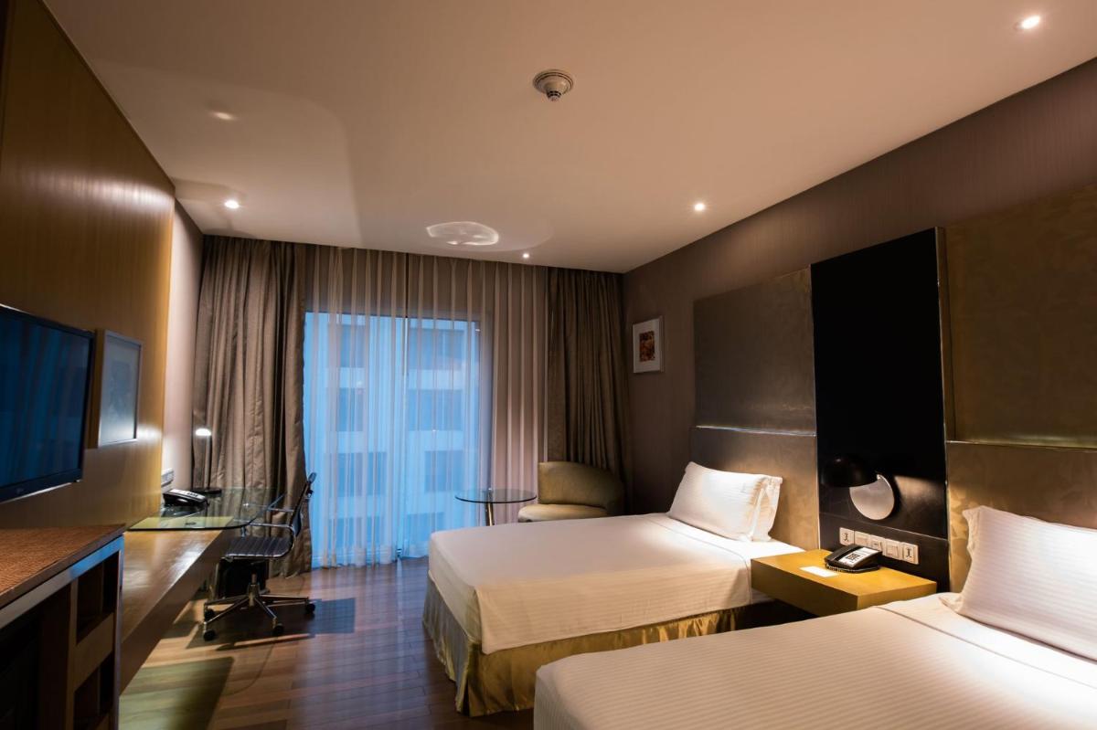 a hotel room with two beds and a television at Holiday Inn New Delhi Aerocity by IHG in New Delhi