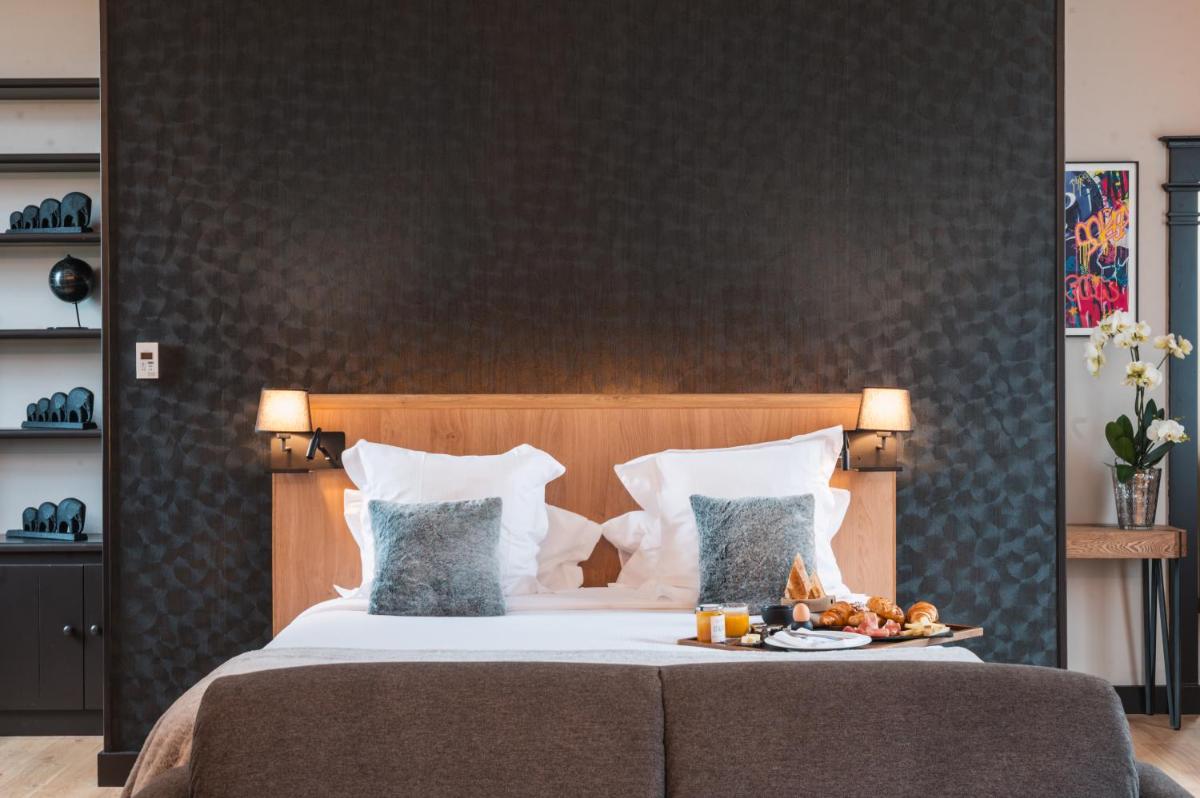 Un ou plusieurs lits dans un hébergement de l'établissement Le Monastère de Saint Mont Hôtel & Spa