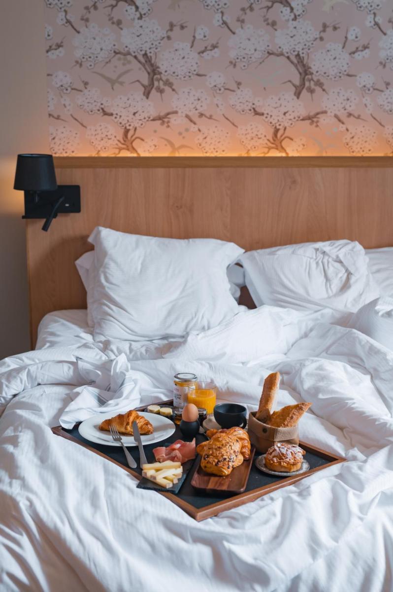 Un ou plusieurs lits dans un hébergement de l'établissement Le Monastère de Saint Mont Hôtel & Spa