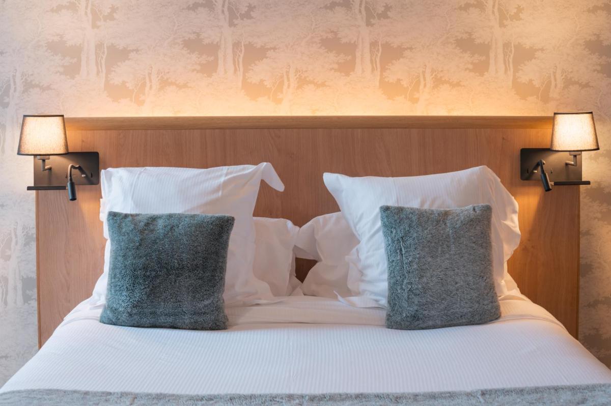 Un ou plusieurs lits dans un hébergement de l'établissement Le Monastère de Saint Mont Hôtel & Spa