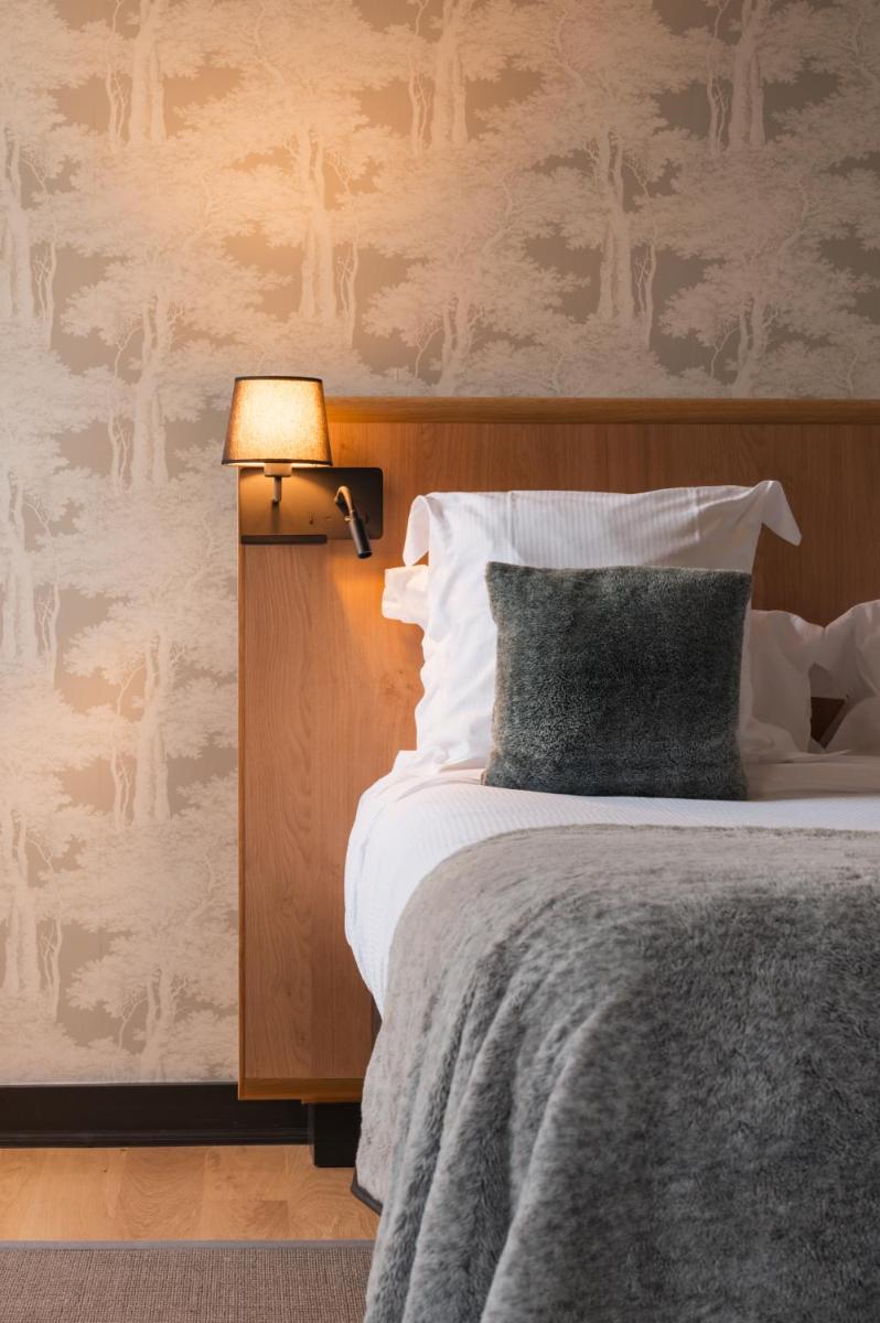 Un ou plusieurs lits dans un hébergement de l'établissement Le Monastère de Saint Mont Hôtel & Spa