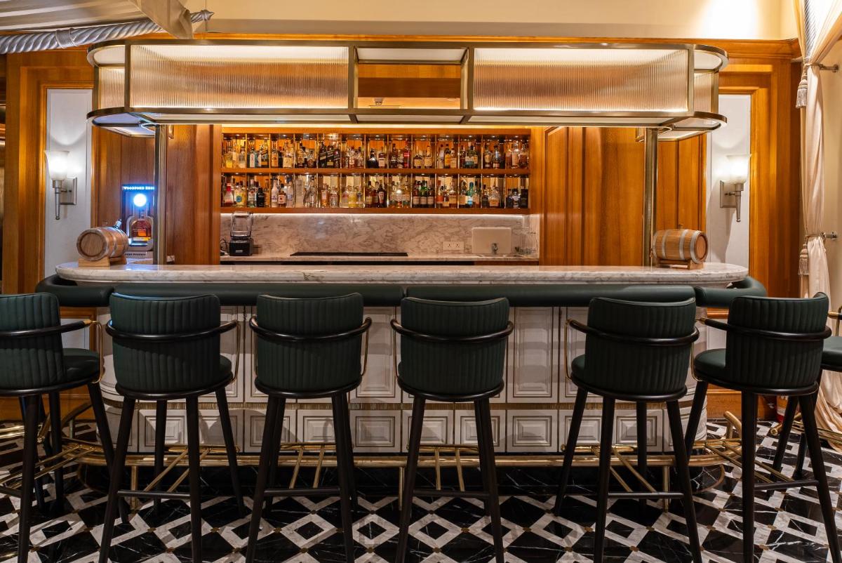 a bar in a restaurant with black stools at Hilton Mumbai International Airport Hotel in Mumbai