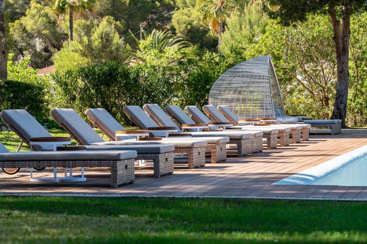 Una fila de tumbonas junto a una piscina. en Hotel Ritual de Terra & SPA Moraira, en Moraira
