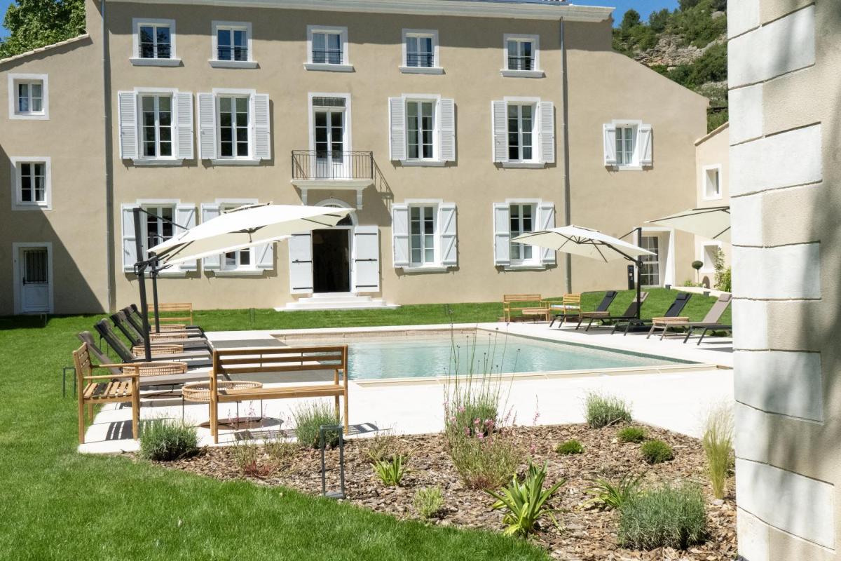 une maison avec une piscine avec chaises et parasols dans l'établissement Château de l'insolas, à Villeneuve-lès-Avignon