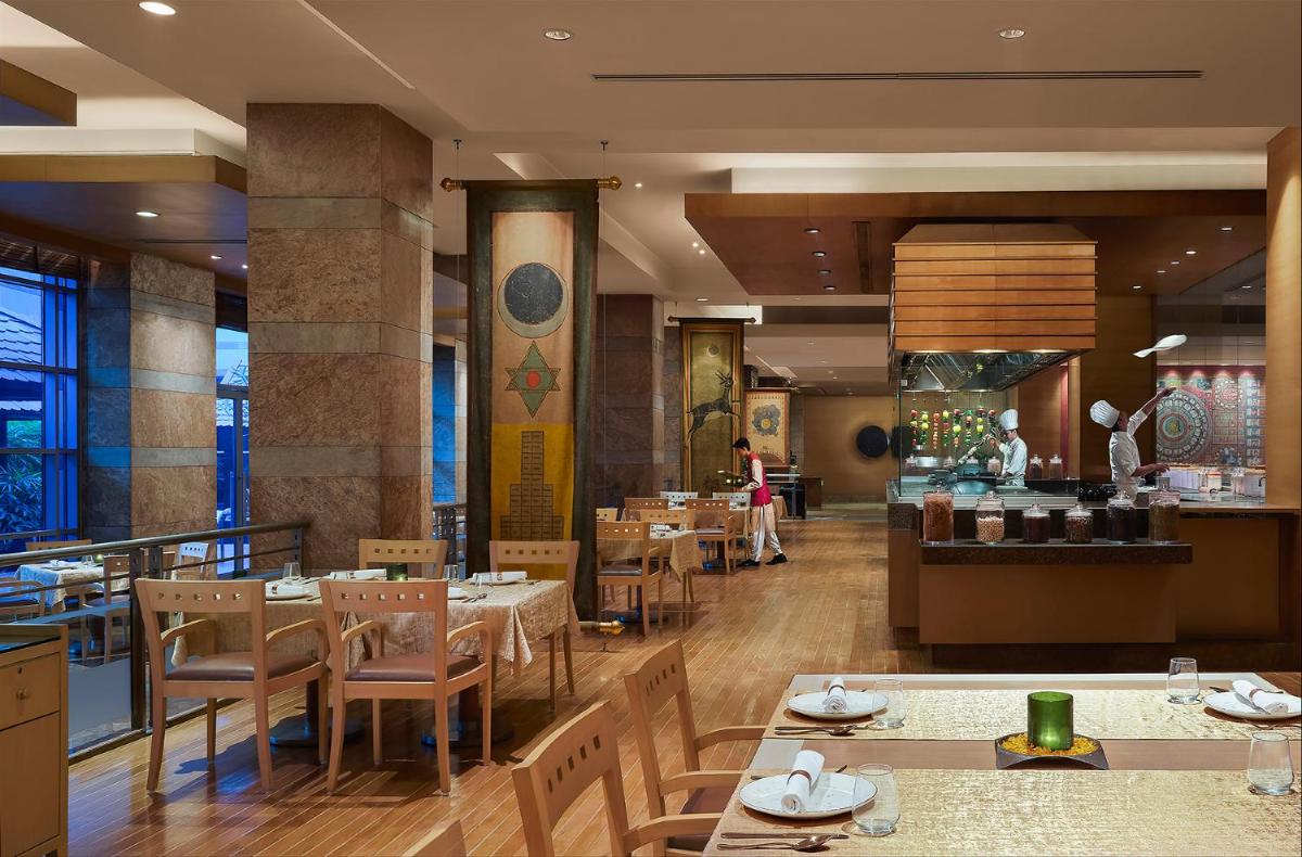 a dining room with tables and chairs in a restaurant at Grand Hyatt Mumbai Hotel and Residences in Mumbai