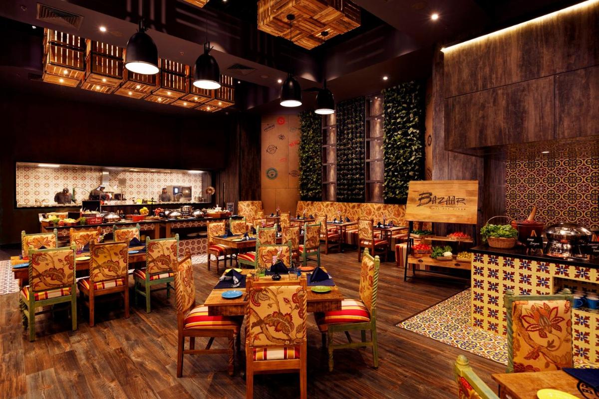a restaurant with tables and chairs in a room at Grand Chennai by GRT Hotels in Chennai
