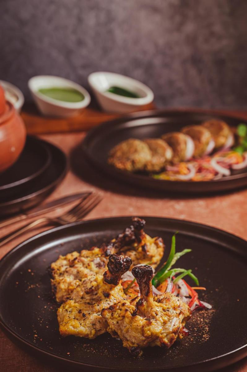 a table with two plates of food on a table at Novotel Kolkata Hotel and Residences in Kolkata a table with two plates of food on a table at Novotel Kolkata Hotel and Residences in Kolkata