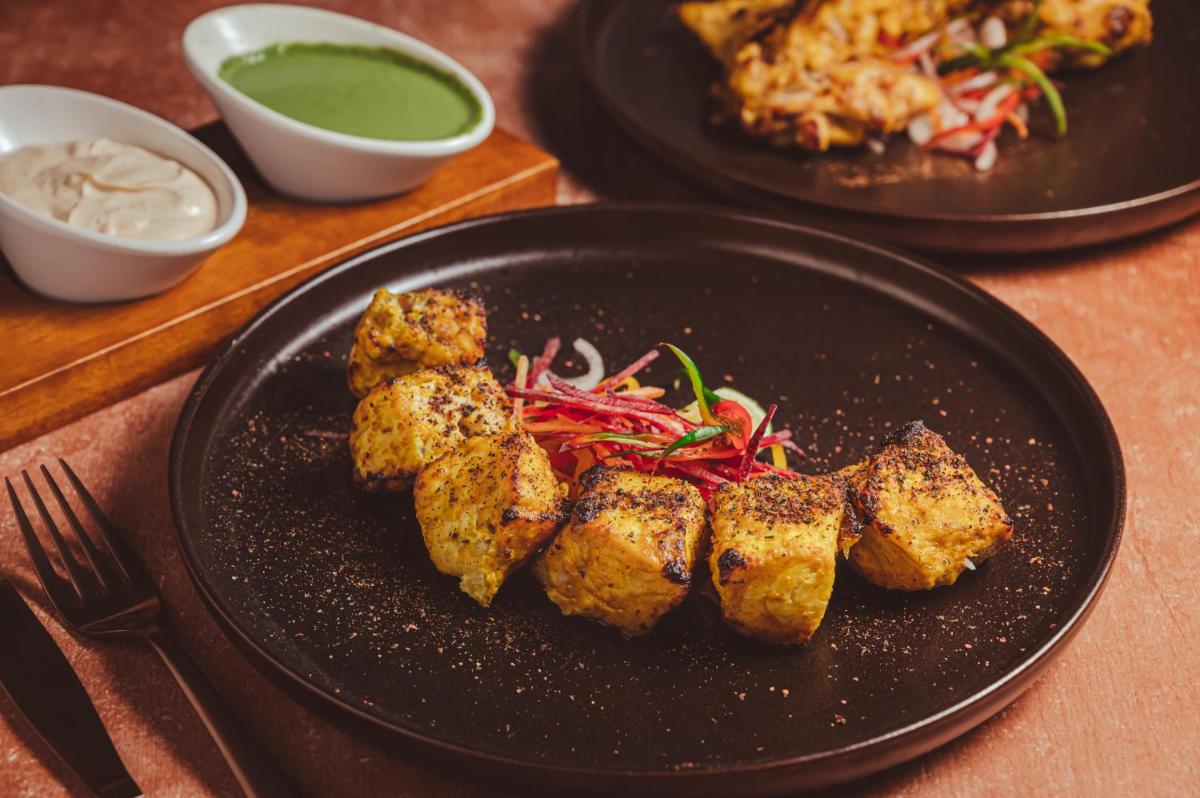 two black plates of food on a table at Novotel Kolkata Hotel and Residences in Kolkata two black plates of food on a table at Novotel Kolkata Hotel and Residences in Kolkata