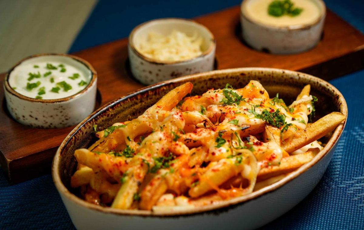 a bowl of pasta with french fries and sauce at Novotel Kolkata Hotel and Residences in Kolkata a bowl of pasta with french fries and sauce at Novotel Kolkata Hotel and Residences in Kolkata