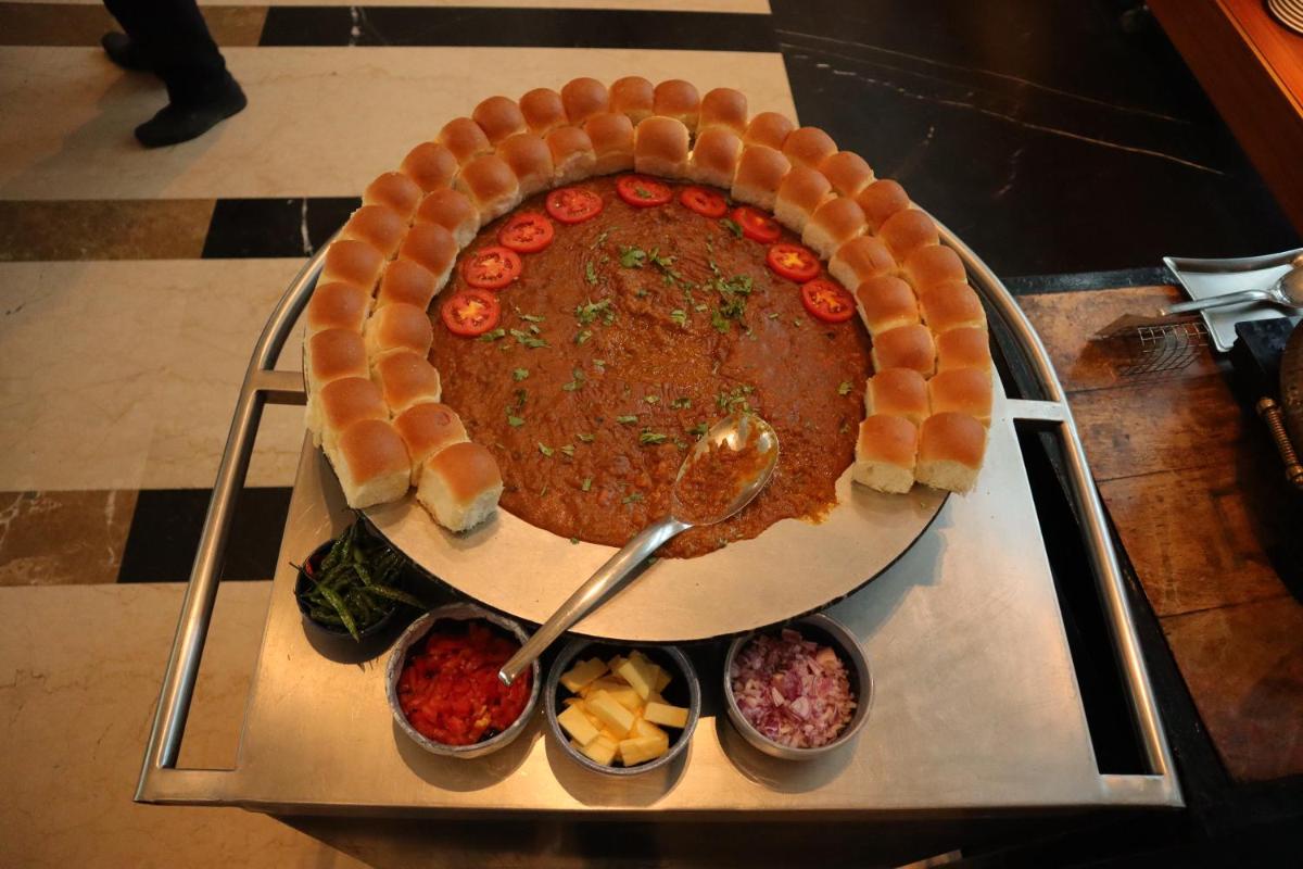 a large funnel cake on a tray with bowls of food at Novotel Kolkata Hotel and Residences in Kolkata a large funnel cake on a tray with bowls of food at Novotel Kolkata Hotel and Residences in Kolkata