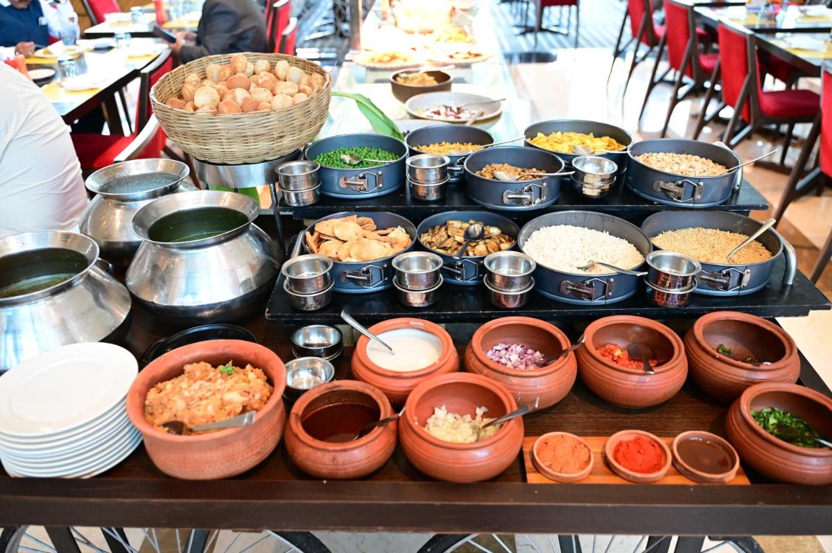 a table with many bowls of food on it at Novotel Kolkata Hotel and Residences in Kolkata a table with many bowls of food on it at Novotel Kolkata Hotel and Residences in Kolkata