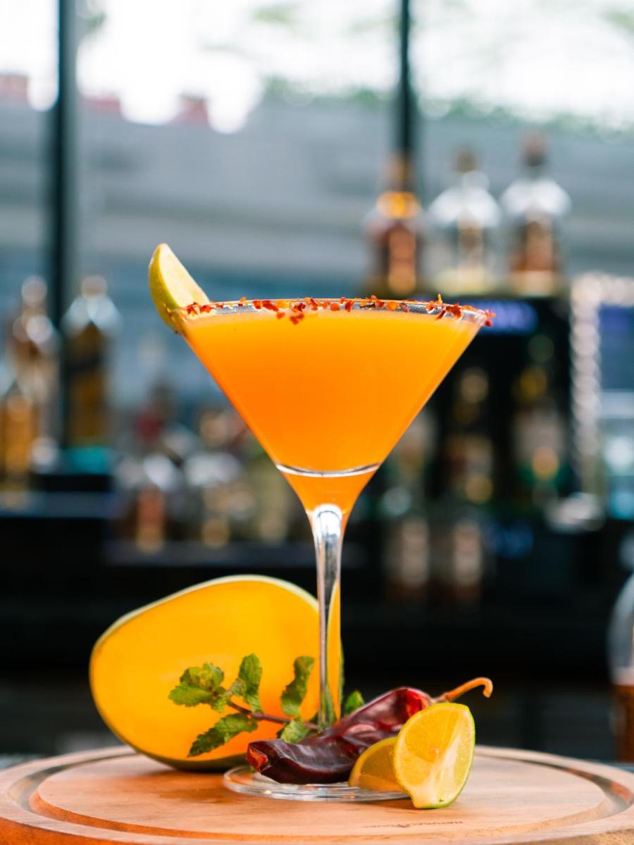 a drink in a martini glass sitting on a table at Novotel Kolkata Hotel and Residences in Kolkata a drink in a martini glass sitting on a table at Novotel Kolkata Hotel and Residences in Kolkata