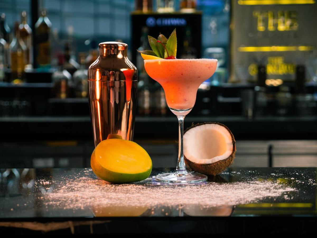 a drink in a martini glass sitting on a bar at Novotel Kolkata Hotel and Residences in Kolkata a drink in a martini glass sitting on a bar at Novotel Kolkata Hotel and Residences in Kolkata