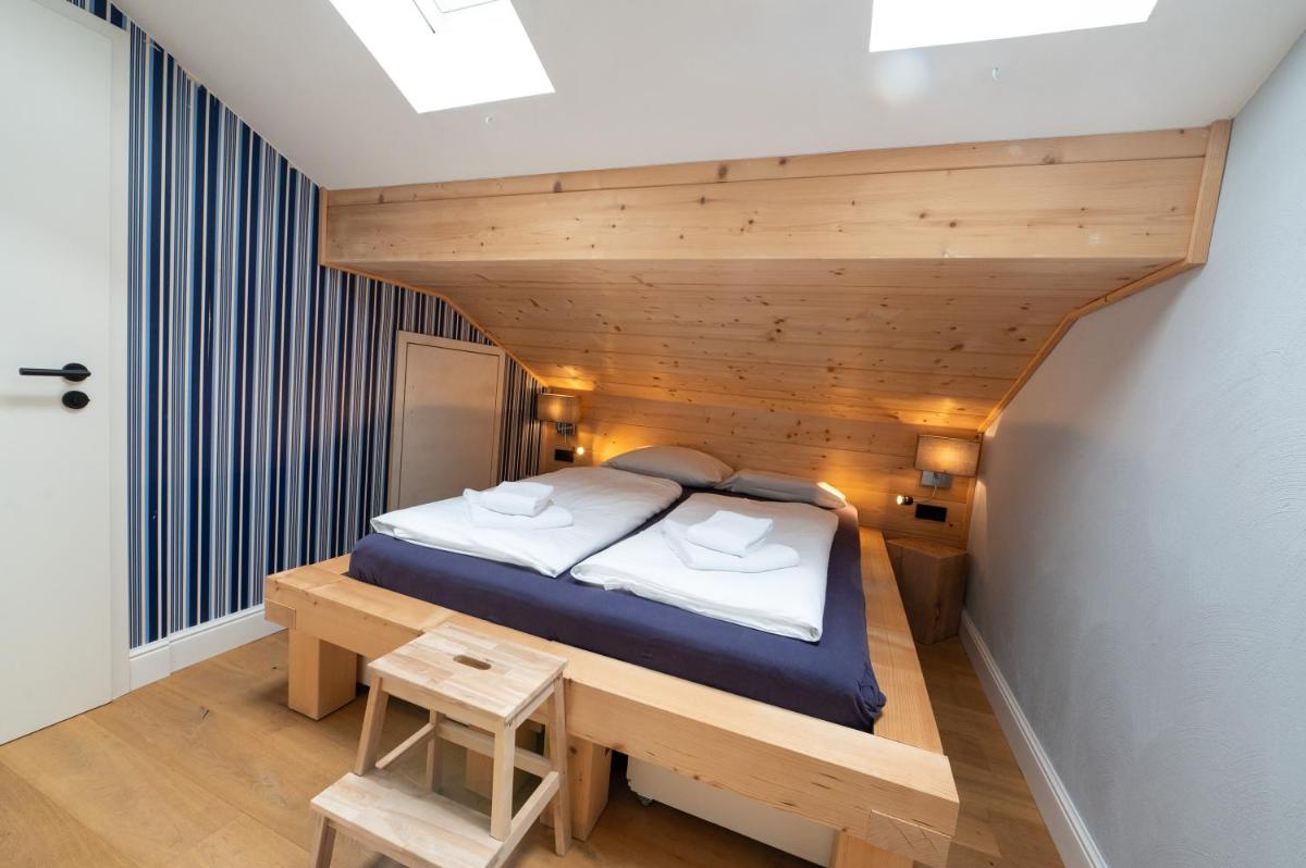 ein Bett in einem Zimmer mit Holzdecke in der Unterkunft ALPENLIEBE - Sauna & Whirlpool - APARTments in Inzell