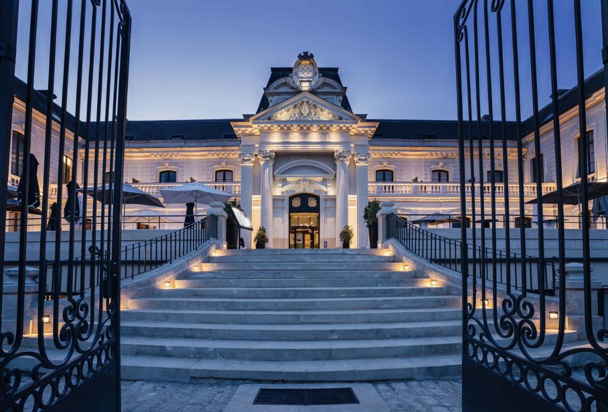 un bâtiment avec des escaliers menant à un bâtiment avec une tour d'horloge dans l'établissement Best Western Premier Hotel de la Cite Royale, à Loches