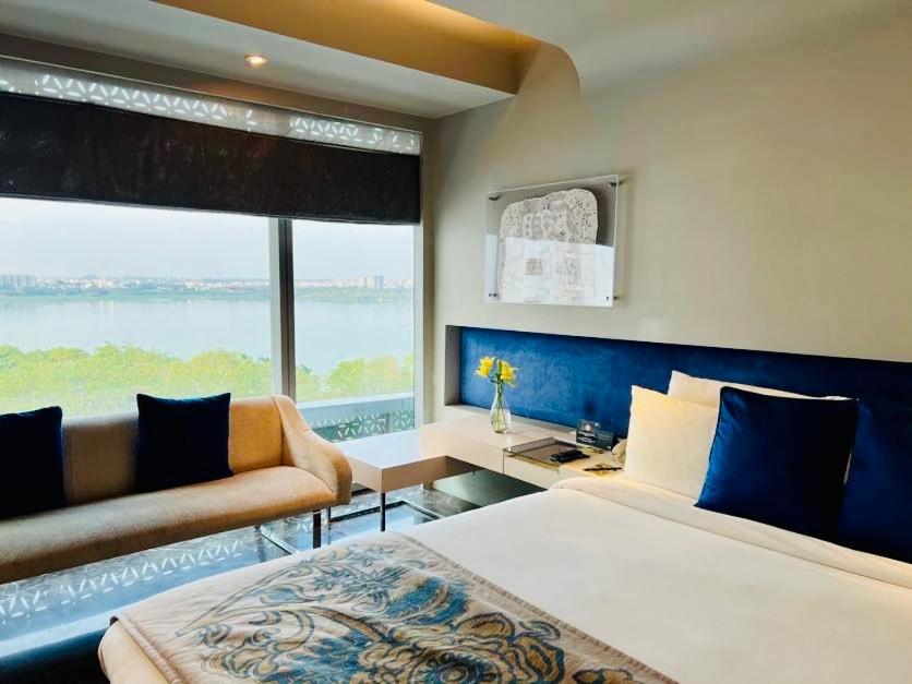 a bedroom with two beds and a couch and a window at The Park Hyderabad, Banjara Hills near Hussain Sagar Lake in Hyderabad a bedroom with two beds and a couch and a window at The Park Hyderabad, Banjara Hills near Hussain Sagar Lake in Hyderabad