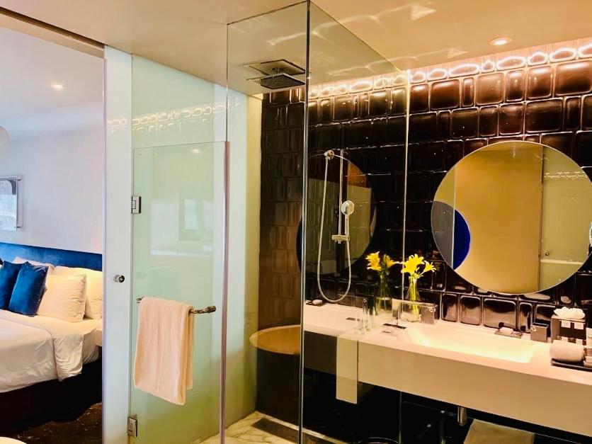 a bathroom with a sink and a mirror and a bed at The Park Hyderabad, Banjara Hills near Hussain Sagar Lake in Hyderabad a bathroom with a sink and a mirror and a bed at The Park Hyderabad, Banjara Hills near Hussain Sagar Lake in Hyderabad