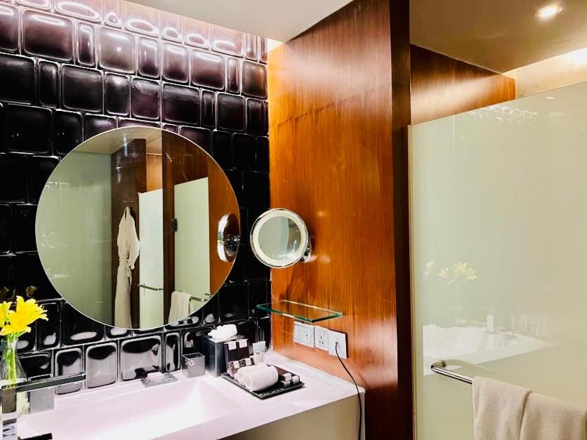 a bathroom with a sink and a mirror at The Park Hyderabad, Banjara Hills near Hussain Sagar Lake in Hyderabad a bathroom with a sink and a mirror at The Park Hyderabad, Banjara Hills near Hussain Sagar Lake in Hyderabad