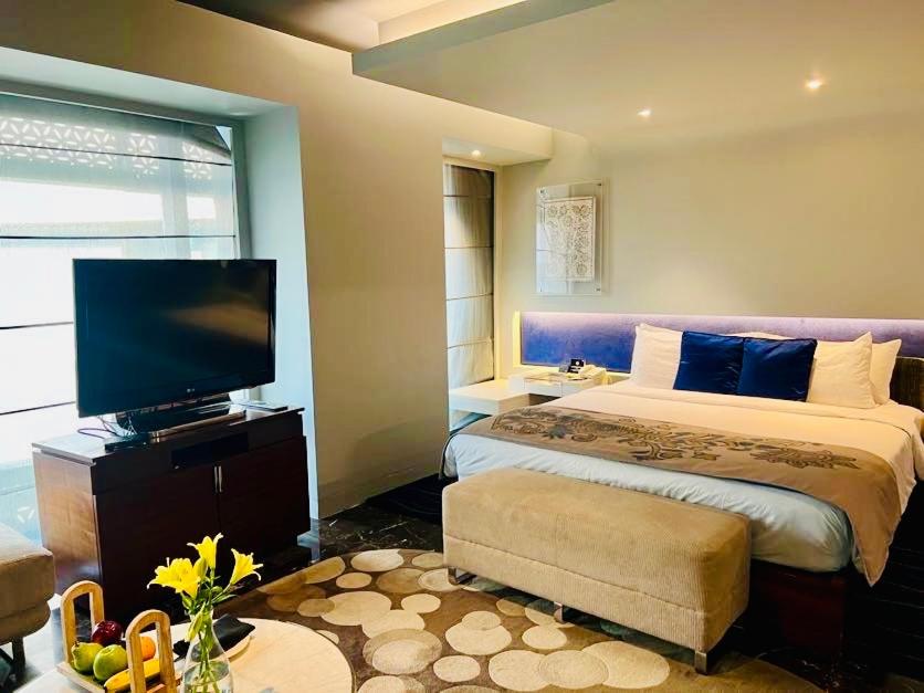 a bedroom with a large bed and a flat screen tv at The Park Hyderabad, Banjara Hills near Hussain Sagar Lake in Hyderabad a bedroom with a large bed and a flat screen tv at The Park Hyderabad, Banjara Hills near Hussain Sagar Lake in Hyderabad
