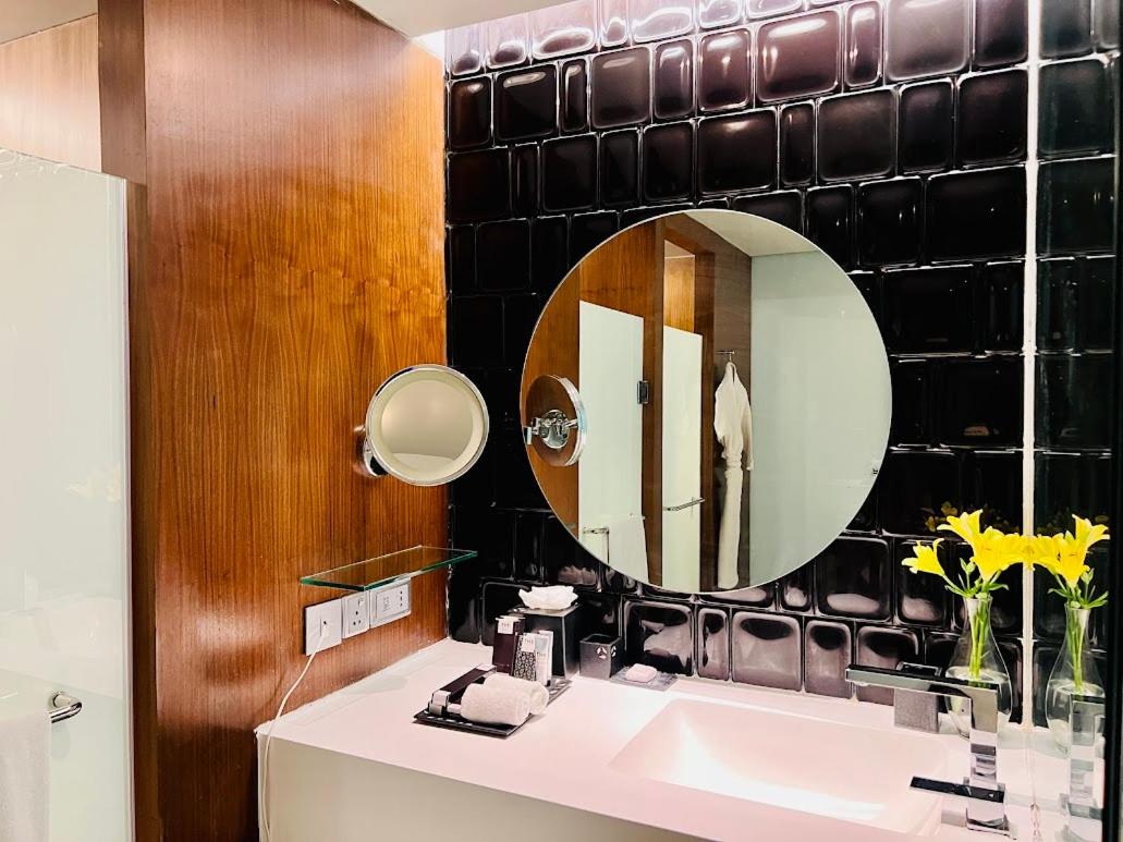 a bathroom with a sink and a mirror at The Park Hyderabad, Banjara Hills near Hussain Sagar Lake in Hyderabad a bathroom with a sink and a mirror at The Park Hyderabad, Banjara Hills near Hussain Sagar Lake in Hyderabad