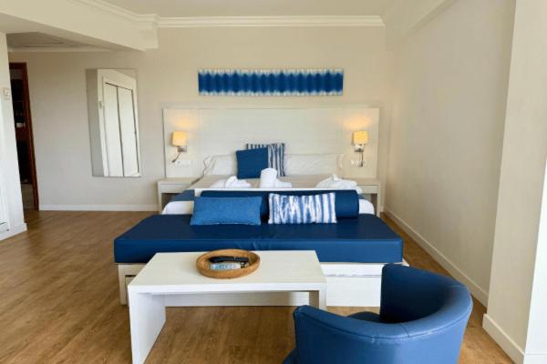 Un dormitorio con una cama azul y una mesa blanca. en Cabot Pollensa Park Spa, en Puerto Pollensa 152 fotos más