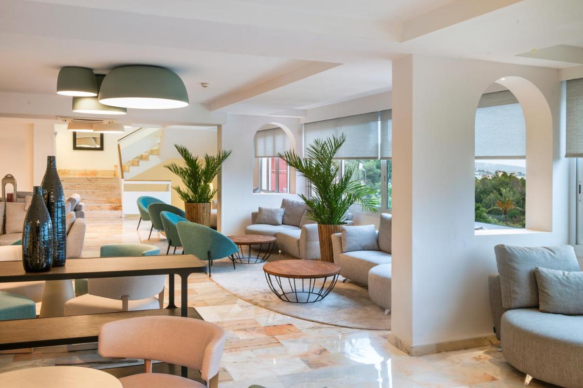 una sala de estar con sofás y sillas en Salles Hotels Marina Portals, en Portals Nous