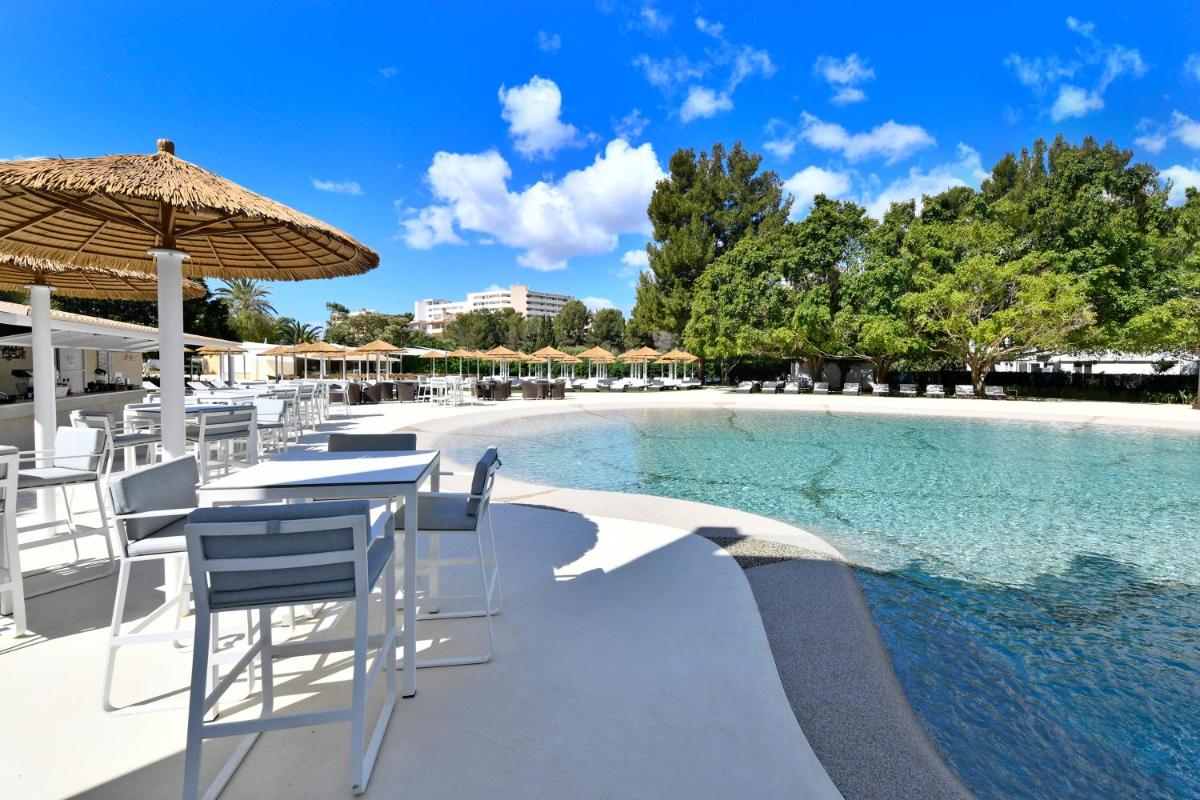 - Piscina con mesas, sillas y sombrilla en Salles Hotels Marina Portals, en Portals Nous