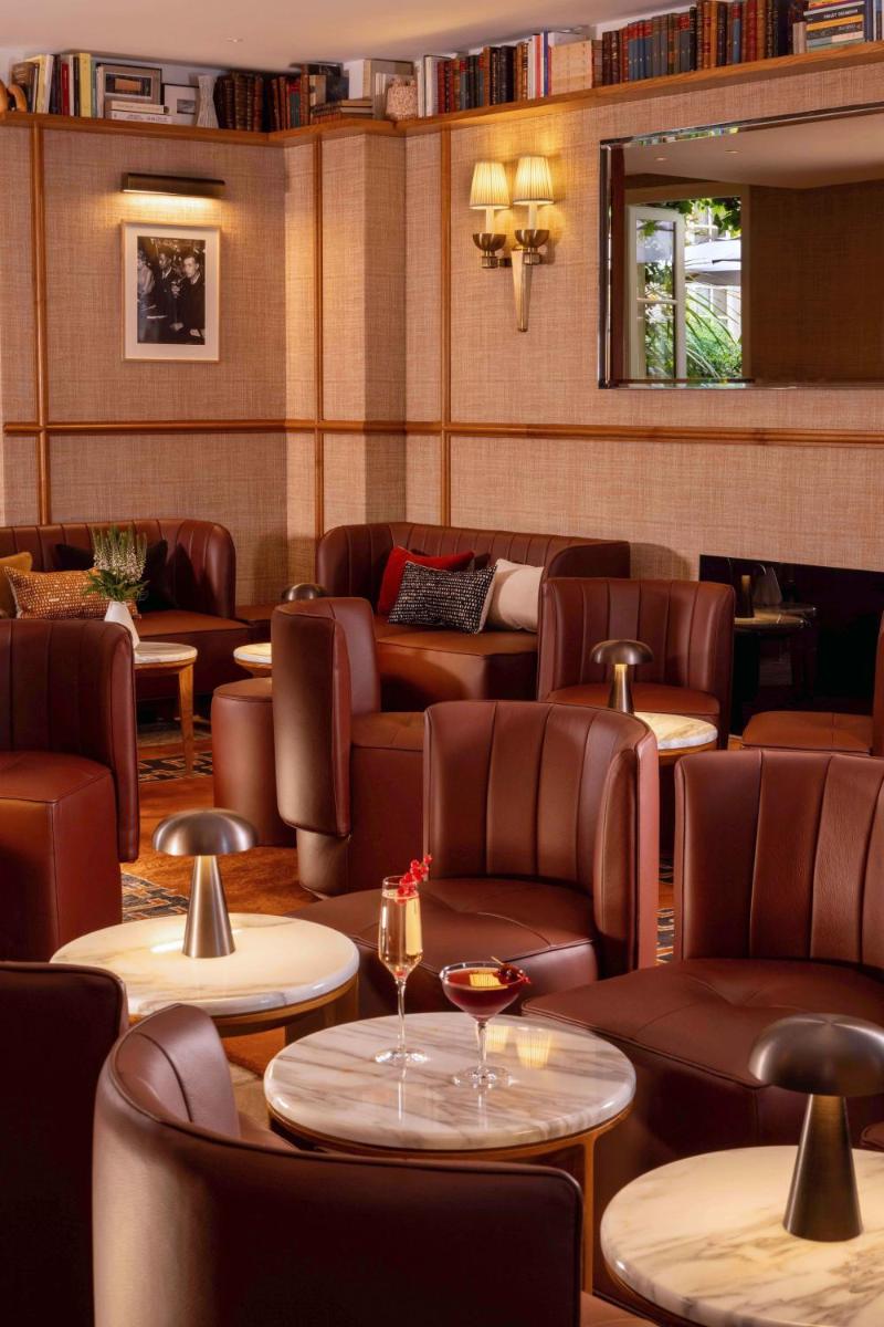 un restaurant avec des canapés, des tables et des chaises dans l'établissement Hôtel D'Aubusson, à Paris