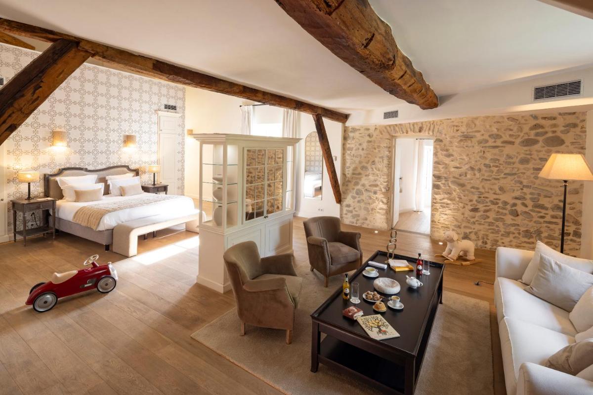 une chambre avec un lit et un salon dans l'établissement Château Les Oliviers de Salettes, à Charols