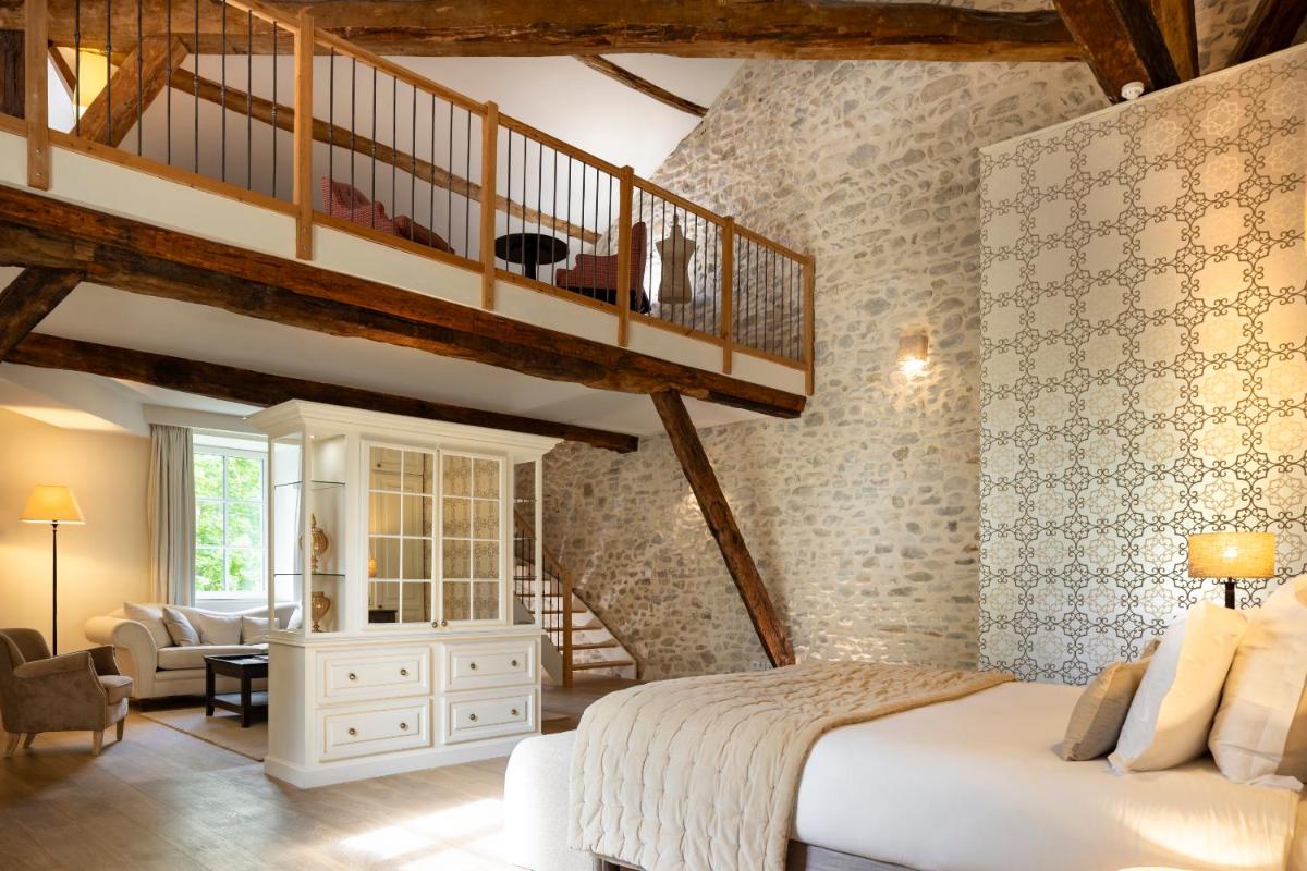 une chambre avec un grand lit et un escalier dans l'établissement Château Les Oliviers de Salettes, à Charols 72 autres photos
