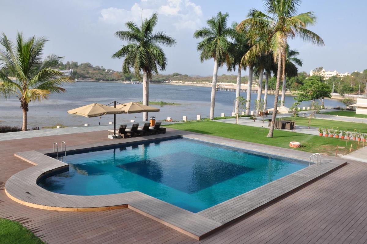 a swimming pool with a view of the water at Hotel Lakend in Udaipur