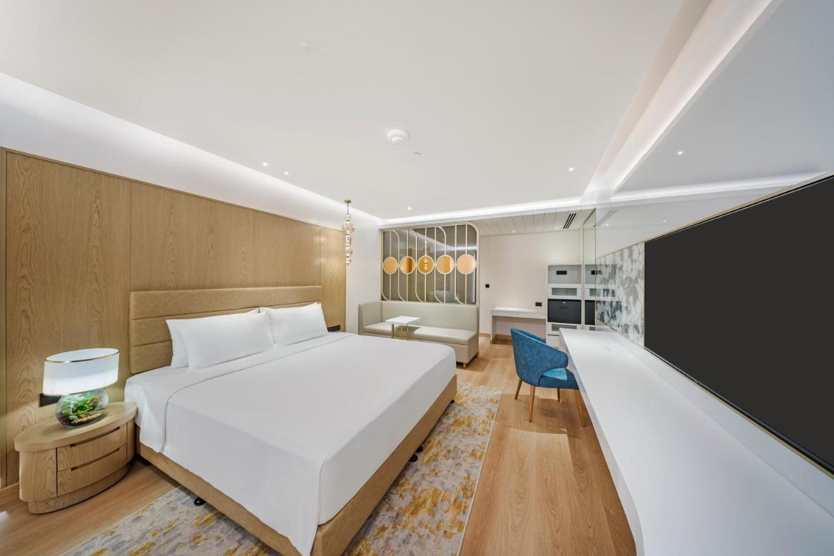 a bedroom with a large white bed and a slide at Radisson Blu Hotel & Suites GRT Chennai in Chennai