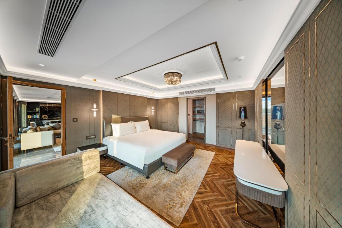 a bedroom with a bed and a desk at Radisson Blu Hotel & Suites GRT Chennai in Chennai