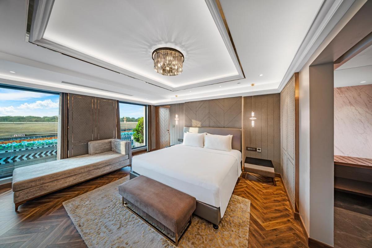 a bedroom with a bed and a large window at Radisson Blu Hotel & Suites GRT Chennai in Chennai