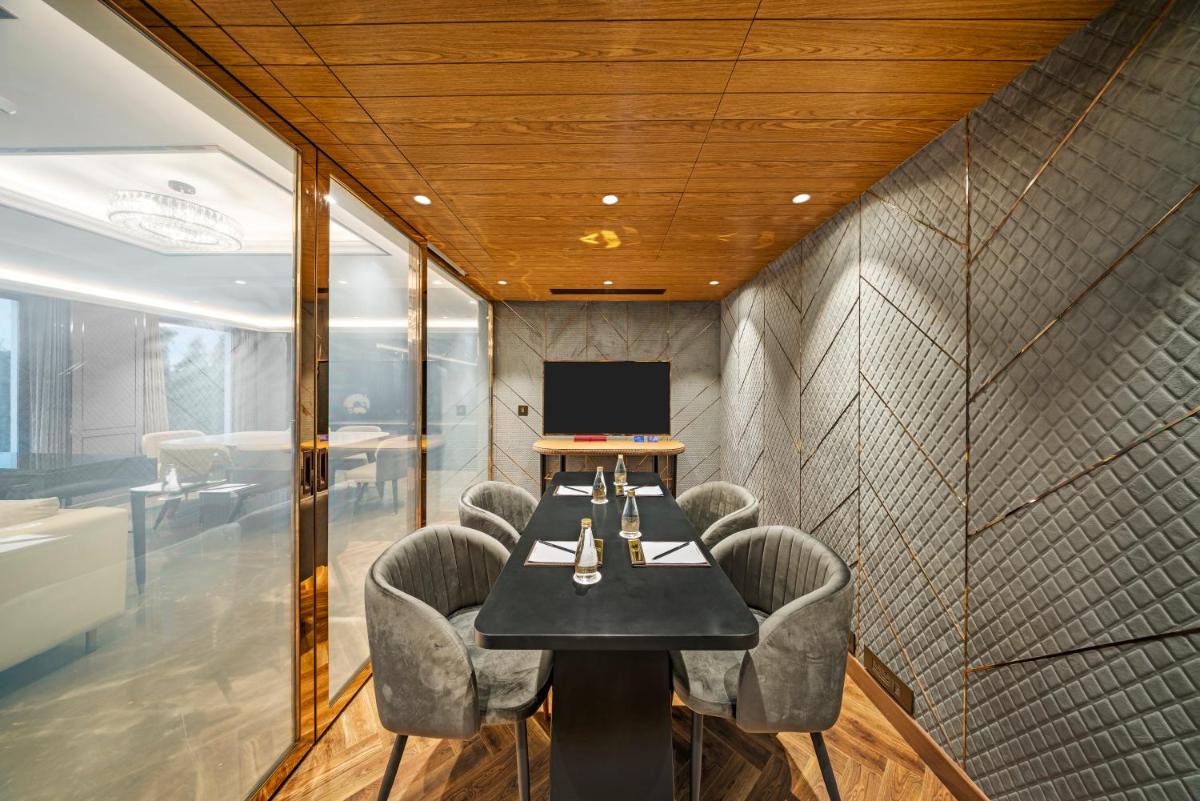 a conference room with a table with chairs and a laptop at Radisson Blu Hotel & Suites GRT Chennai in Chennai