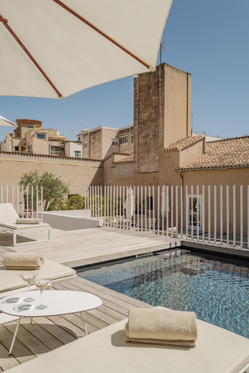 Una piscina con un patio y un edificio. en Convent de la Missio - Grand Luxury Boutique hotel, Adults Only, en Palma de Mallorca