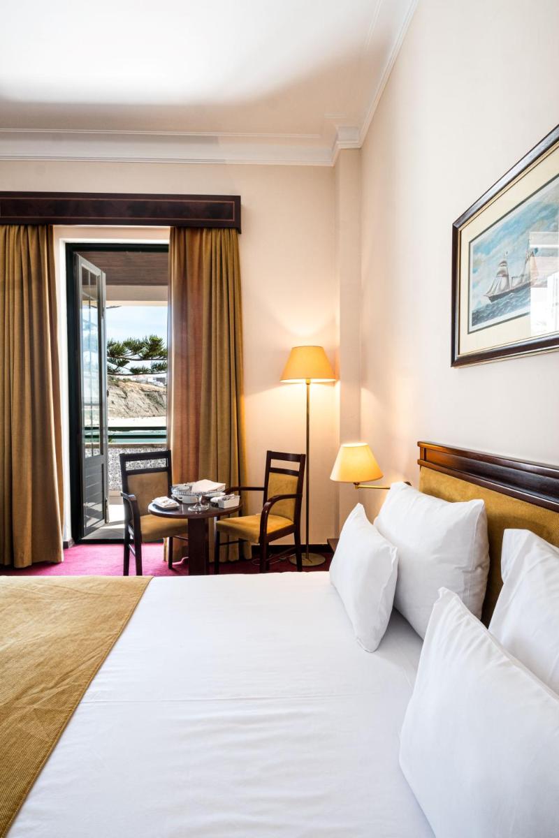 um quarto de hotel com uma cama e uma mesa em Vila Gale Ericeira na Ericeira