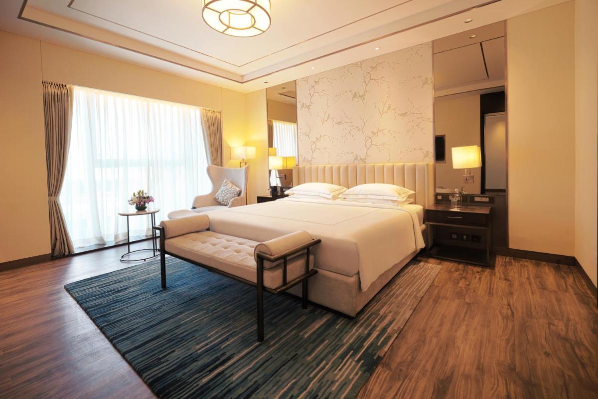 a hotel room with a bed and a window at Taj Bangalore in Devanahalli-Bangalore