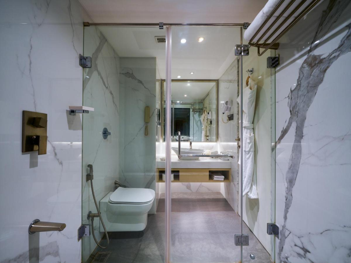 a bathroom with a shower and a toilet and a sink at Sayaji Pune in Pune