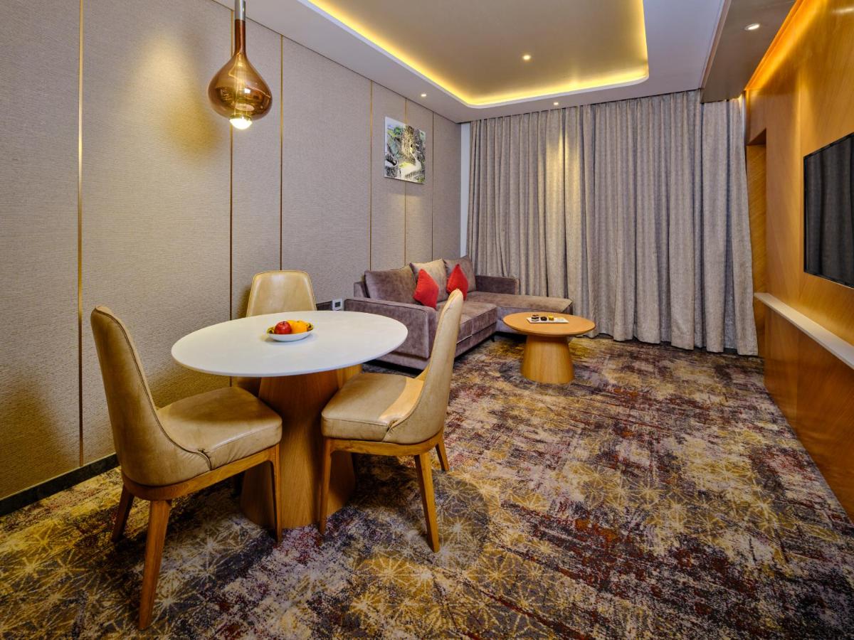 a living room with a table and chairs and a couch at Sayaji Pune in Pune
