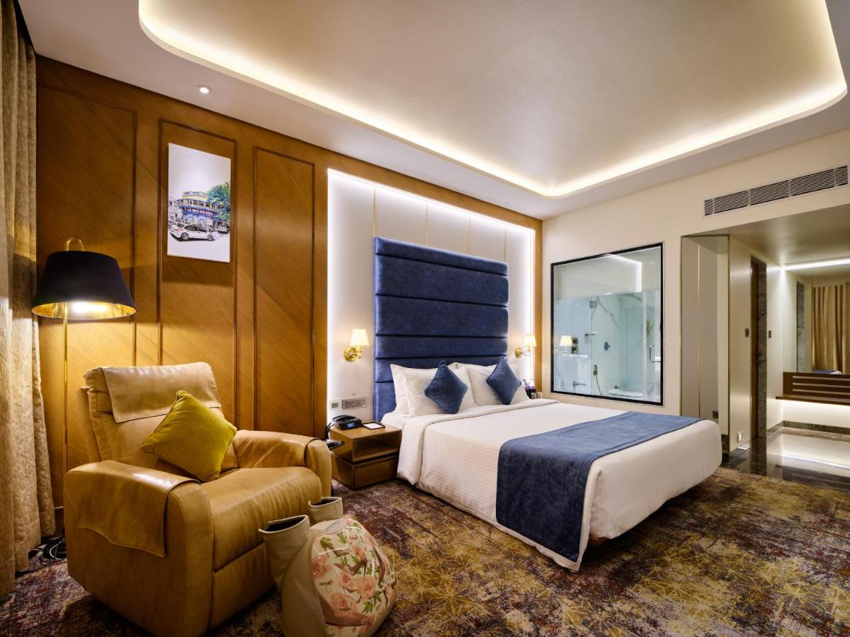 a hotel room with a bed and a chair at Sayaji Pune in Pune