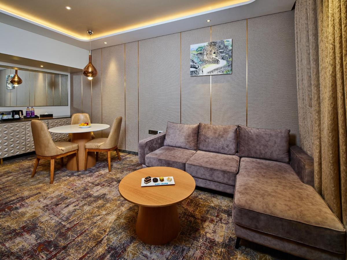 a living room with a couch and a table at Sayaji Pune in Pune